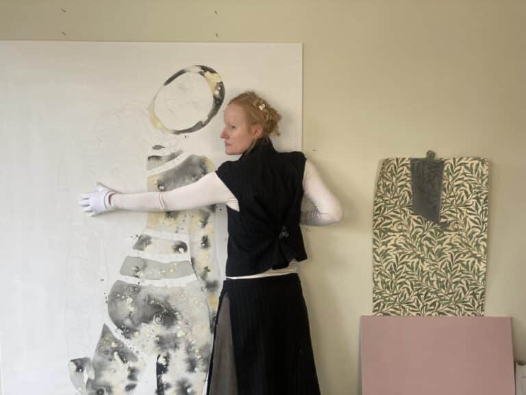 The artist Sandra Ackermann in front of one of her paintings.